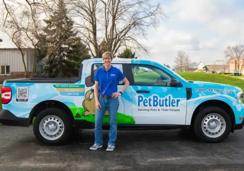 Dana Burkholder, owner of Pet Butler of North Denver, CO standing next to a Pet Butler truck.