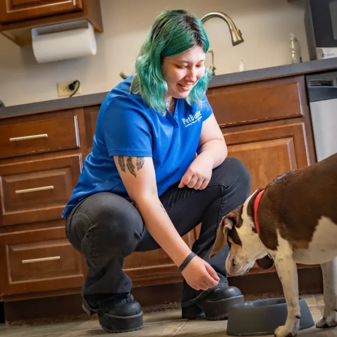 Pet Butler New City NY local manager Feeding and caring for a dog while pet sitting in a kitchen. Dog Sitter - Pet Care Services