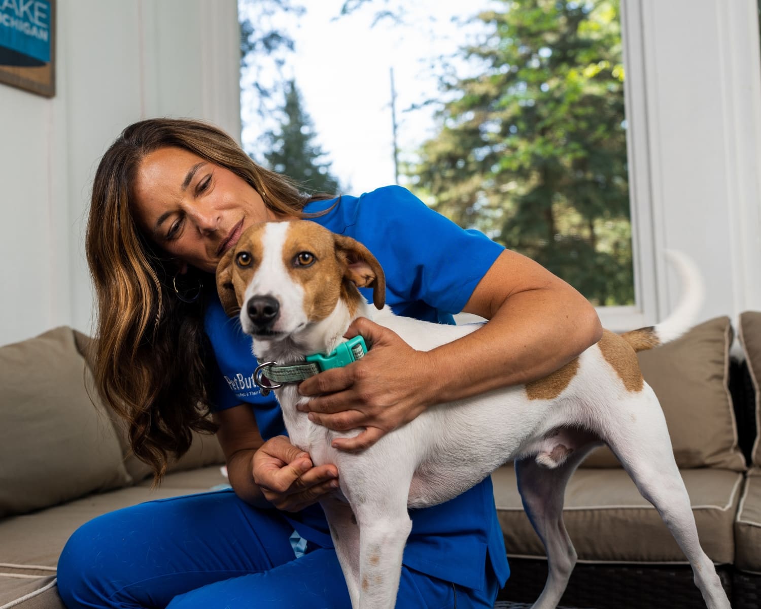 woman-in-a-blue-uniform-hughing-a-small-dog