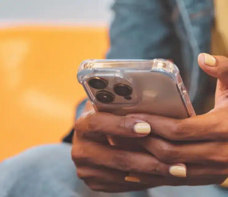 A mobile phone held in the palms of the user's hands.