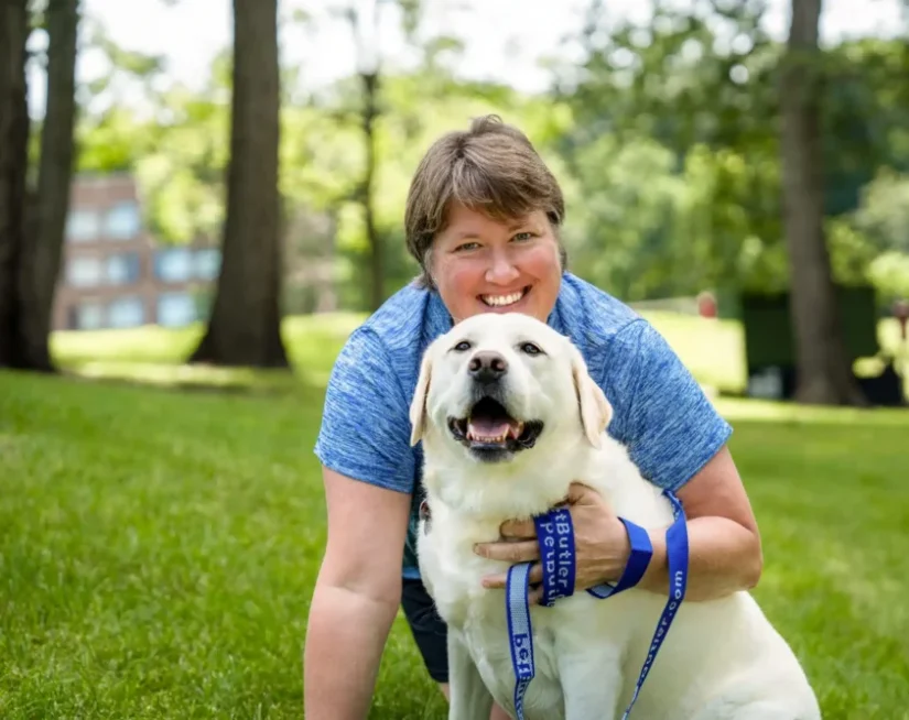 Aimee Braatz, owner of Pet Butler Waukesha WI, posing with a dog while out on a walk